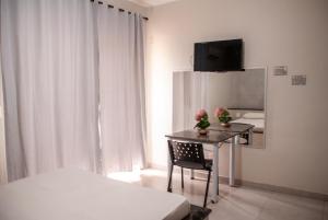 um quarto com uma mesa, uma cama e um espelho em Hotel Viena em Taguatinga