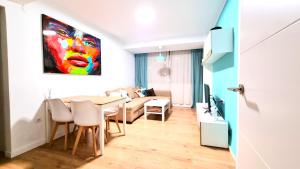 comedor y sala de estar con mesa y pintura en Exclusive Guest Room Experience in Cozy & Modern Apartment - No other guests, en Valencia