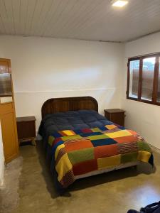 a bedroom with a bed with a colorful quilt at Casa del lago in Embalse