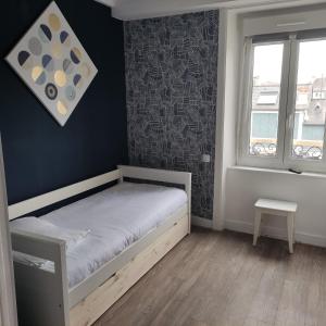 a small bedroom with a bed and a window at Hôtel de Matignon Restaurant Le EmLo in Matignon