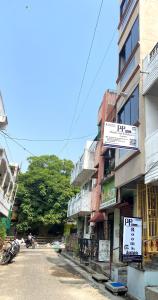 a building with signs on the side of a street at PP White Town Rooms in Puducherry