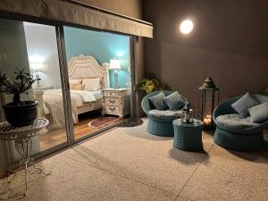 um quarto com 2 cadeiras, uma cama e um espelho em Koombana Retreat em Perth