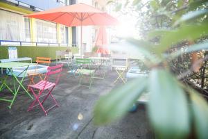 a group of tables and chairs with an umbrella at NunoHotel in Cologne