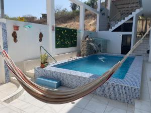 a hammock in a house with a swimming pool at MarAzul, Casa grade familiar en Zorritos in Zorritos