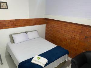 un piccolo letto in una camera con muro di mattoni di Pousada Amazônia a Rio Branco