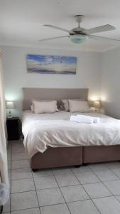 1 dormitorio con 1 cama y ventilador de techo en Gorgeous Self Catering Cottage off Umhlanga Rocks, en Durban