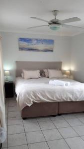 a bedroom with a bed with a ceiling fan at Gorgeous Self Catering Cottage off Umhlanga Rocks in Durban