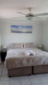 a bedroom with a bed with a ceiling fan at Gorgeous Self Catering Cottage off Umhlanga Rocks in Durban