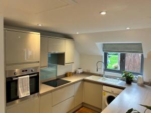 a kitchen with white cabinets and a sink and a dishwasher at Flat in Budleigh Salterton in Budleigh Salterton