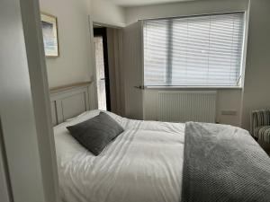a bedroom with a bed with a pillow and a window at Flat in Budleigh Salterton in Budleigh Salterton