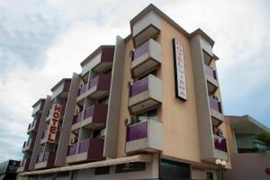 a building with purple balconies and a sign on it at Hotel Viena in Taguatinga