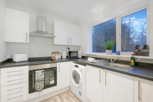 a white kitchen with a sink and a dishwasher at Stylish & Relaxing Retreat in Normanby, Sleeps 4 in Middlesbrough