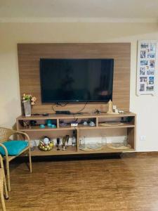 a living room with a flat screen tv on a entertainment center at Sobrado Apartamento de Praia in Pontal do Paraná