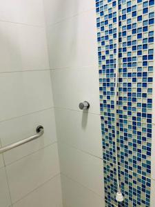 a bathroom with a shower with blue and white tiles at Sobrado Apartamento de Praia in Pontal do Paraná +13 photos