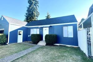 una casa azul con una valla en un patio en OSU Retro Cottage Retreat in PNW, en Corvallis
