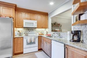 una cocina con electrodomésticos blancos y armarios de madera en Modern McCormick Townhome on Lake Thurmond!, en McCormick