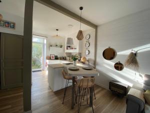 een keuken en een woonkamer met een tafel en stoelen bij Studio au pied du phare Vue Mer in Roscoff