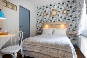 a small bedroom with a bed and a table at Hôtel de Lion sur Mer in Lion-sur-Mer