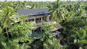 uma vista aérea de uma casa no meio de palmeiras em InnerZen Riverside homestay Ben Tre - Japanese style em Ấp Phú Hòa (3)