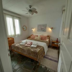 Schlafzimmer mit einem Bett und einem Deckenventilator in der Unterkunft Serenity Maisonnette in Otziás
