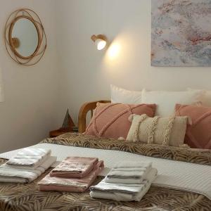 Una cama con toallas plegadas encima. en Serenity Maisonnette, en Otziás