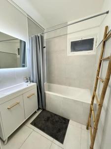 a white bathroom with a shower and a sink at Suite Topaze by STACK  in Lyon