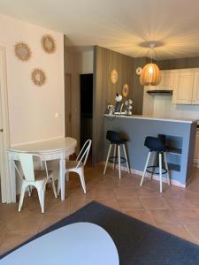 une cuisine avec une table, des chaises et un comptoir dans l'établissement appartement cosy avec climatisation réversible GOLF DE SAUMANE, à Saumane-de-Vaucluse