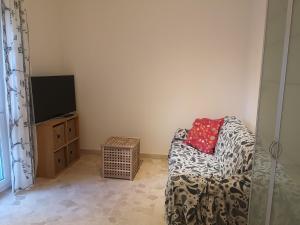 uma sala de estar com um sofá e uma televisão em Appartamento centrale e silenzioso em Casalecchio di Reno