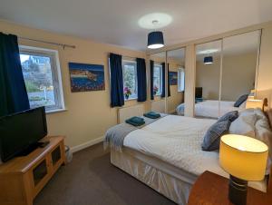 a bedroom with two beds and a flat screen tv at Orchard House in Scarborough