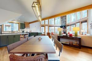 cocina grande con mesa de madera y sillas en The McKenzie River House, en Vida