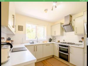 uma cozinha com armários brancos e um forno com placa de fogão em Orchard House em Scarborough