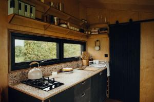 a kitchen with a stove and a counter top at Re Cabins - Reconnect Cabin - St Albans 