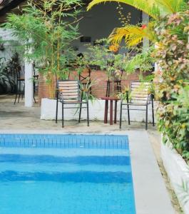 a pool with two chairs and a table and a table and chairsitures at Manoha Villa in Sihanoukville