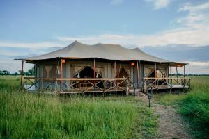 ein großes Zelt in der Mitte eines Feldes in der Unterkunft Zawadi Camp in Serengeti-Savanne