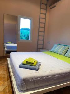 Un dormitorio con una cama con una toalla amarilla. en Agriturismo I Tassoni en Pavullo nel Frignano