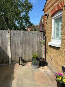a backyard with a wooden fence next to a house at Whitstable Wishes, a Stylish Seaside Retreat, Whitstable with Parking Space in Whitstable