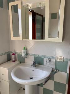y baño con lavabo y espejo. en Residence Mare Sol Appartamento in affitto Budoni, en Porto Ottiolu