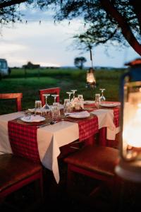 a table with a red and white checkered table cloth at Zawadi Serengeti camp in Serengeti National Park +43 photos