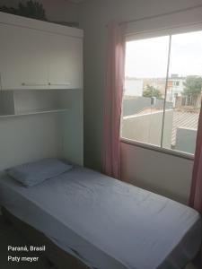 - une petite chambre avec un lit et une fenêtre dans l'établissement Aluguel sobrado pra show rural, à Cascavel