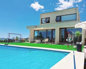 a house with a swimming pool in front of a house at VILLA THE SUN in Concepción