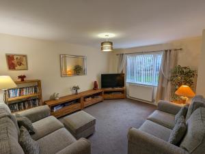 uma sala de estar com 2 sofás e uma televisão de ecrã plano em Orchard House em Scarborough
