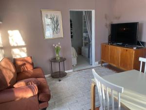 uma sala de estar com um sofá e uma televisão em Small house central Parainen by Archipelago Trail em Pargas