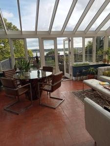 a conservatory with a table and chairs and a couch at Oakhurst Guesthouse in Cobh