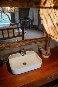 a white sink in a bathroom with a mirror at Zawadi Serengeti camp in Serengeti National Park