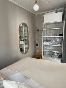 um quarto com uma cama branca e um espelho em Small house central Parainen by Archipelago Trail em Pargas