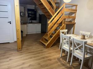 a kitchen and dining room with a table and a staircase at Domki nad morzem " Przy Lesie" in Kopalino