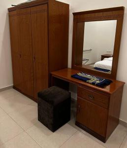 a bathroom with a wooden vanity and a mirror at شاطئ الأحلام الحديث للشقق المخدومة in Taif