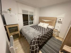 a small bedroom with a bed and a television at El Patio de Lucy in Puerto de Sagunto