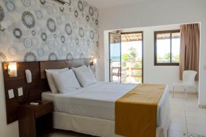 a hotel room with a bed and a balcony at G2 Beach Hotel in Aquiraz