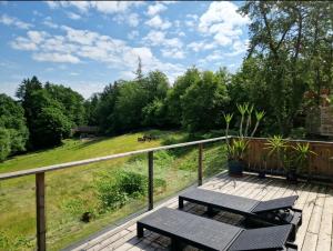 una terraza con 2 mesas de picnic y un campo en Naturstammhaus Pauker, en Klagenfurt